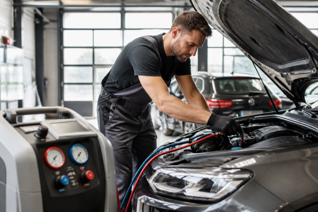 Garagiste inspectant une climatisation de voiture dans l'atelier du Garage Crauzaz Nurieux