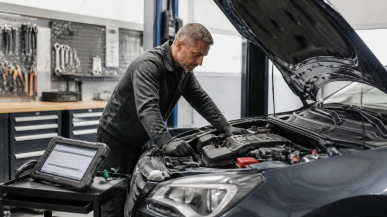 Garagiste professionnel effectuant un diagnostic automobile dans un garage moderne