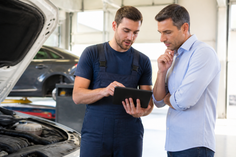 Garagiste expliquant les résultats du contrôle technique à un client dans un garage